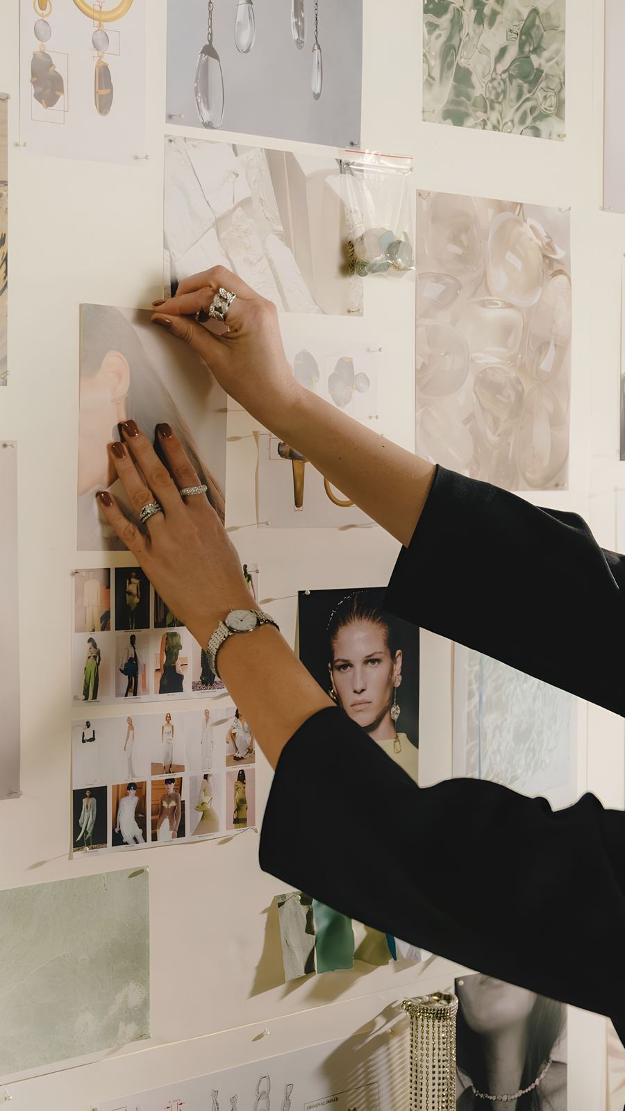 Hands pinning images to a moodboard