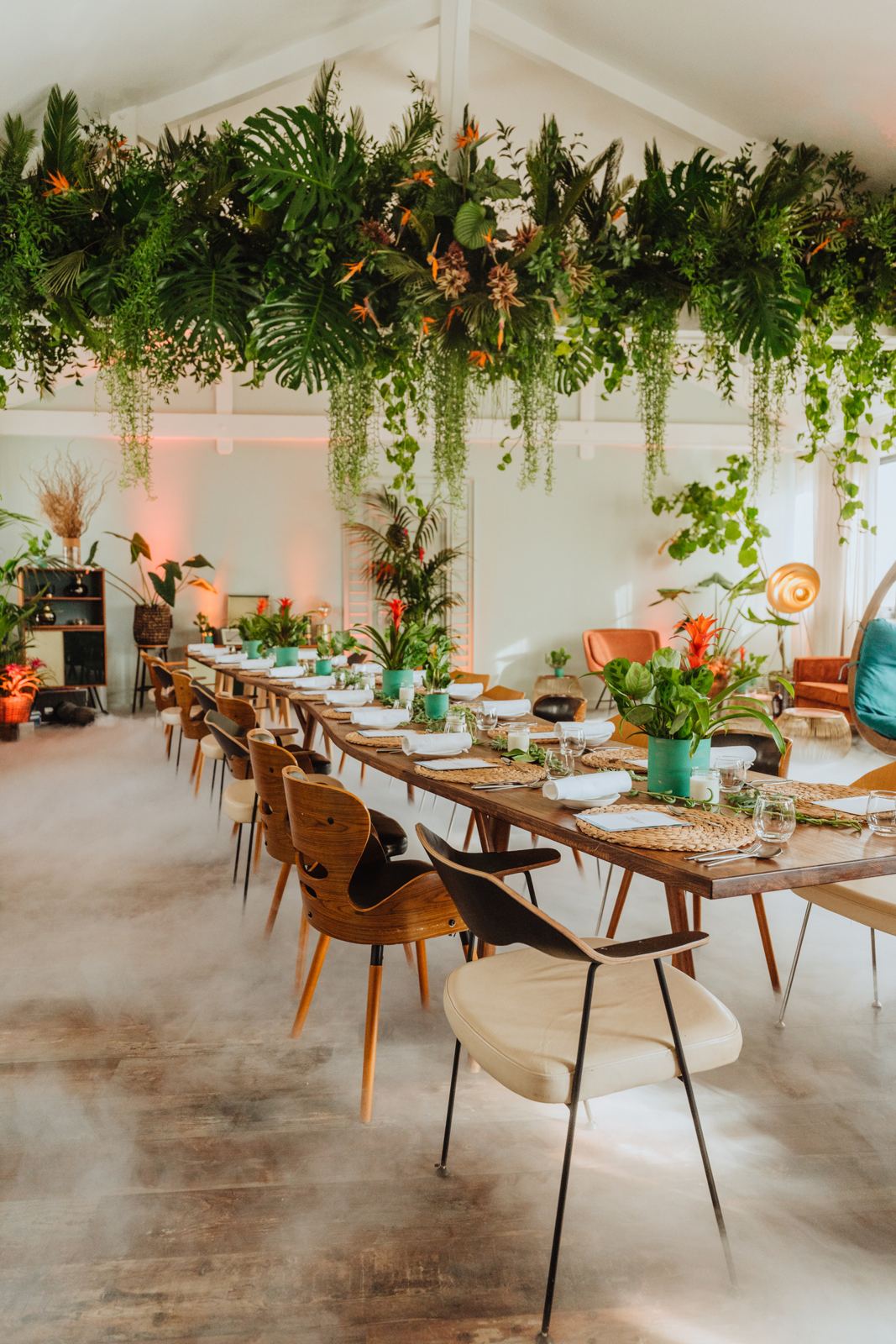 Long dinner table under hanging greenery